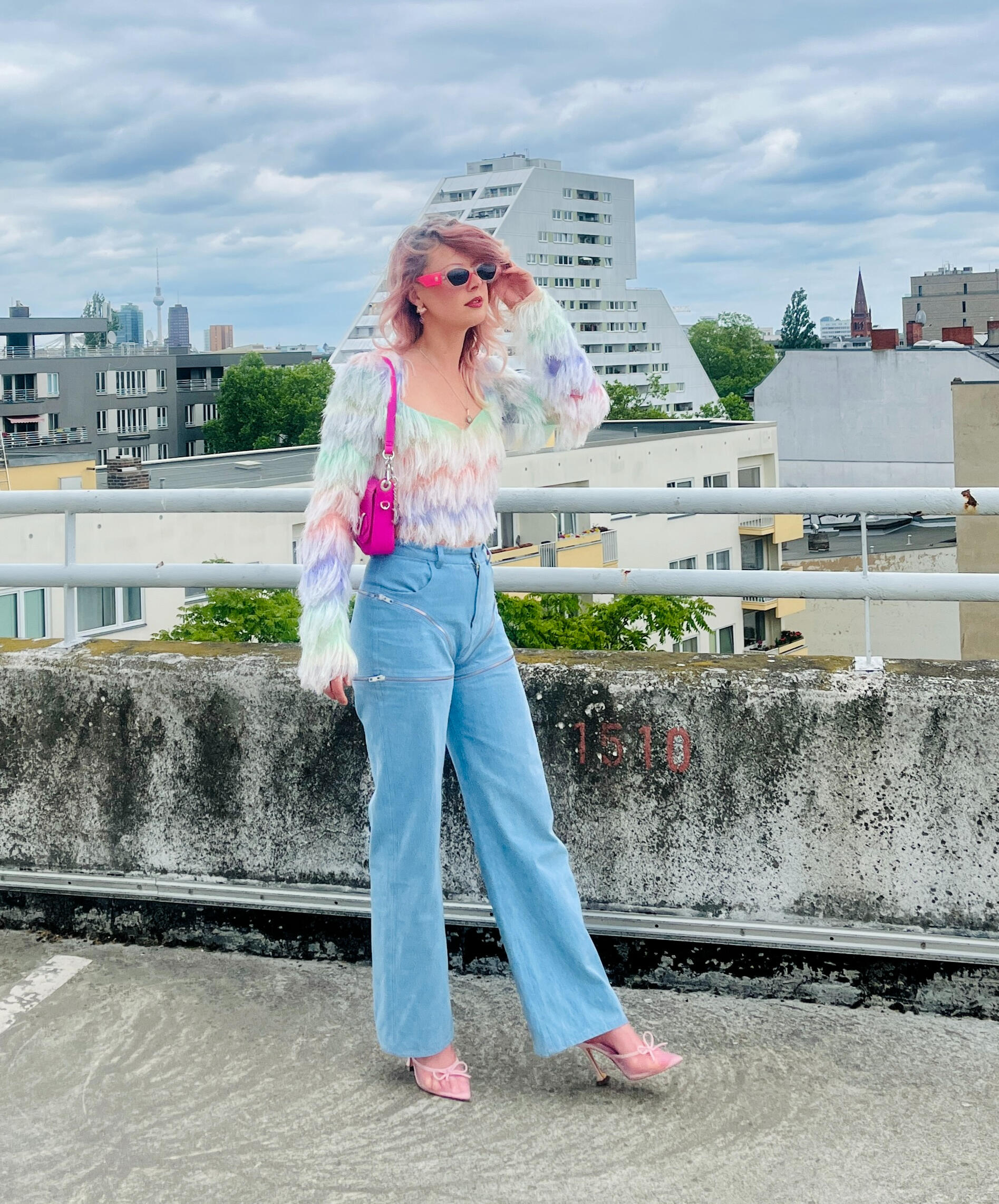 ephani modular wide-leg jeans styled on a Berlin rooftop with a pastel fringe top and pink bag